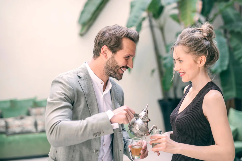 A well-dressed couple enjoying tea together